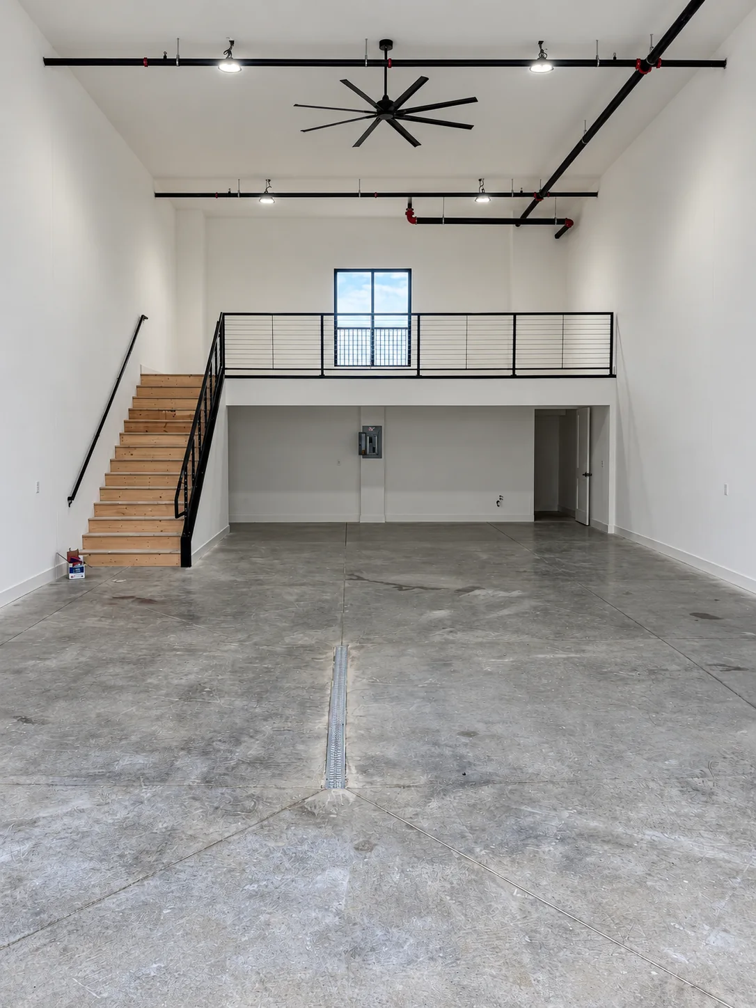 Garage interior with unfinished wood stairs and a mezzanine